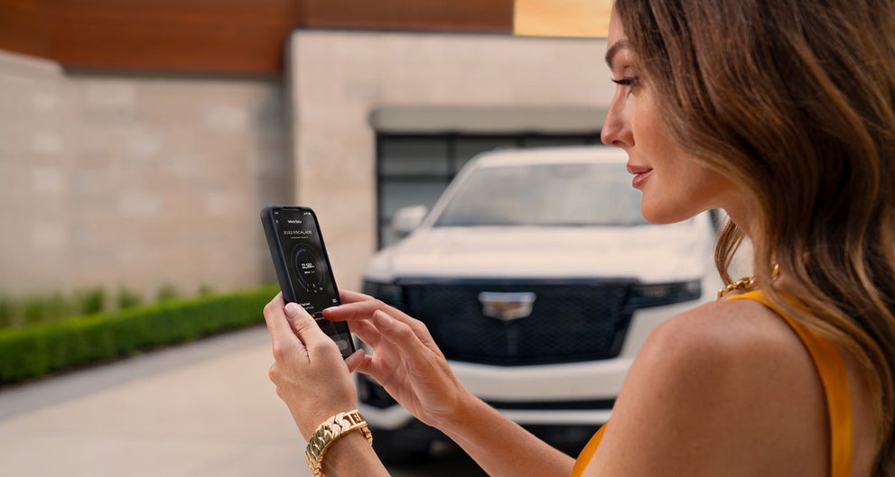 lady checking her mobile with a Cadillac vehicle background | Graham Cadillac in MANSFIELD OH